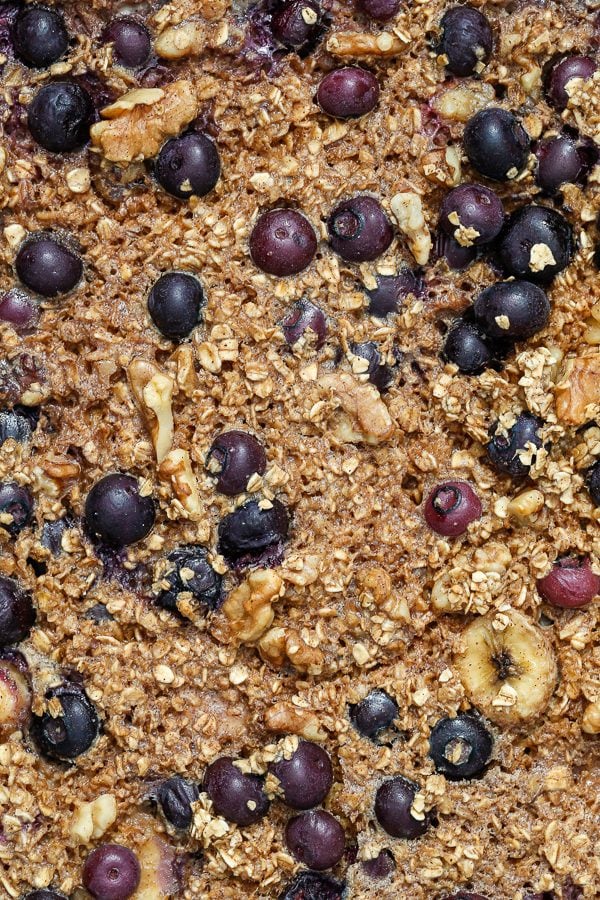 baked oatmeal including blueberries, walnuts, bananas, and oats in a container