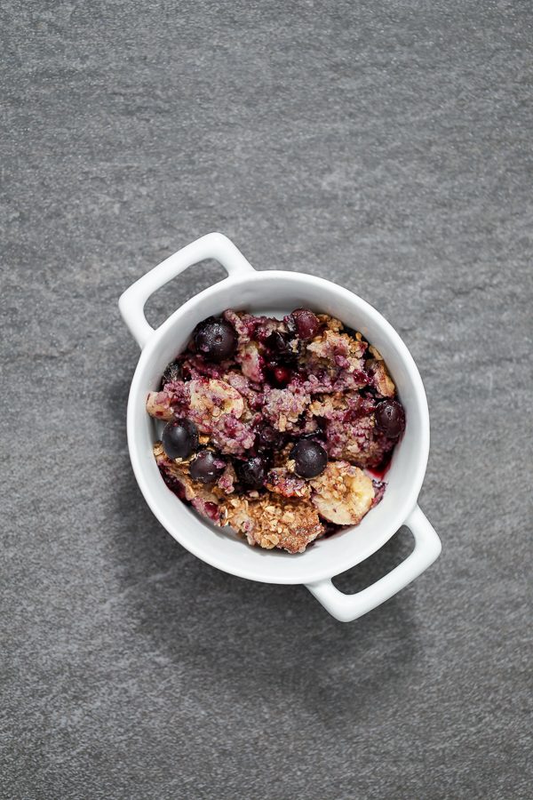 baked oatmeal including blueberries, walnuts, bananas, and oats in a container