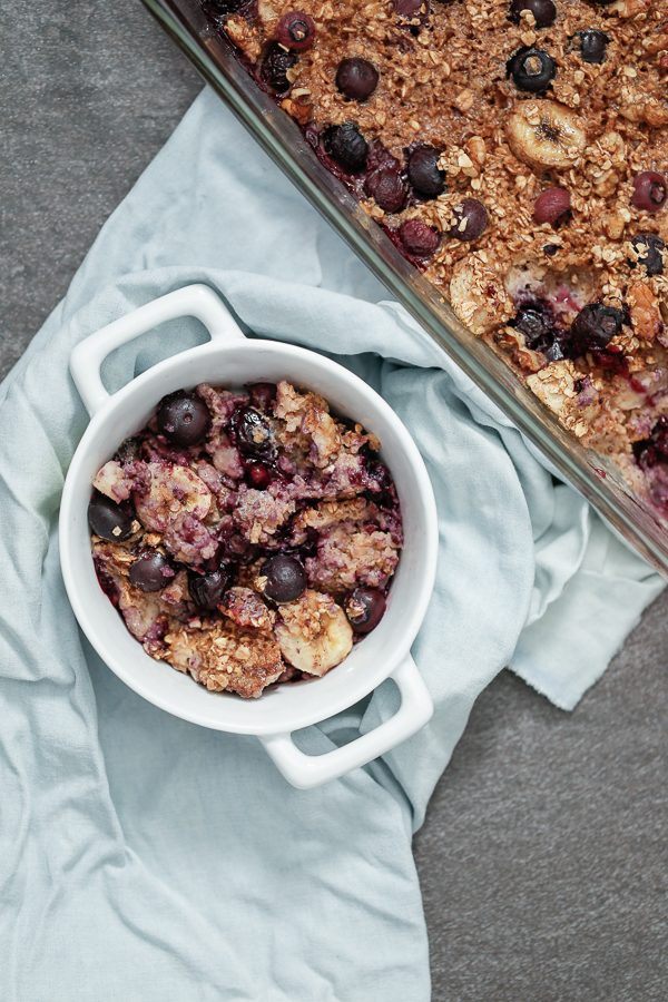 baked oatmeal including blueberries, walnuts, bananas, and oats in a container