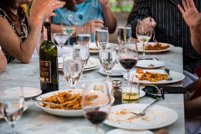 People dining outside with food and wine