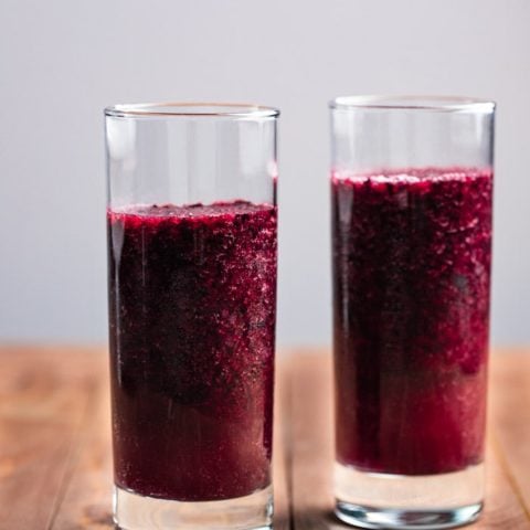 two clear glasses filled with blueberry slush